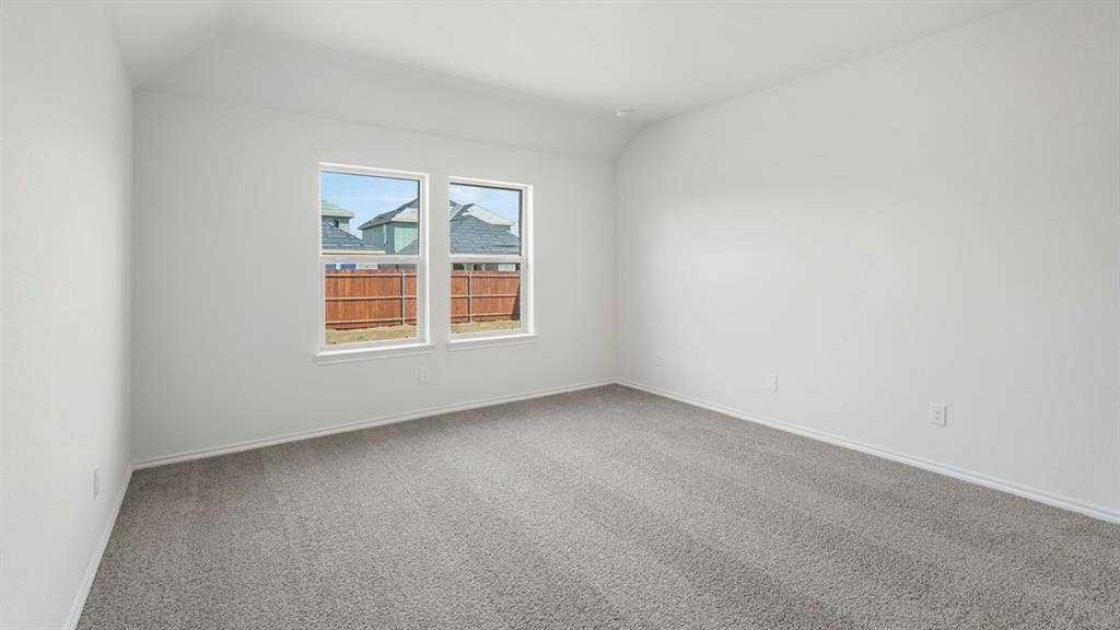 Spacious room featuring neutral carpeting, white walls, and two large windows
