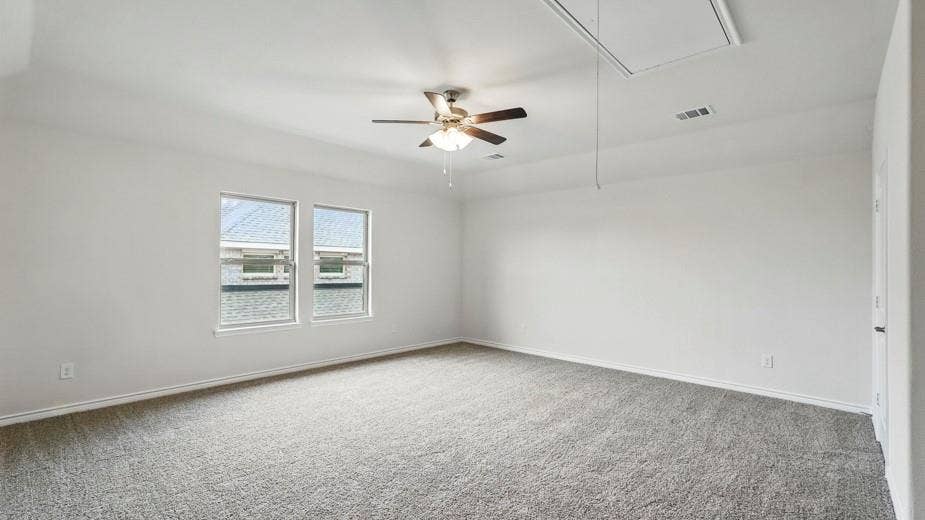 2510 Wesley Avenue, Royse City, TX 75189 Spacious room with plush gray carpeting, two large windows, a ceiling fan with light fixture, and an attic access panel