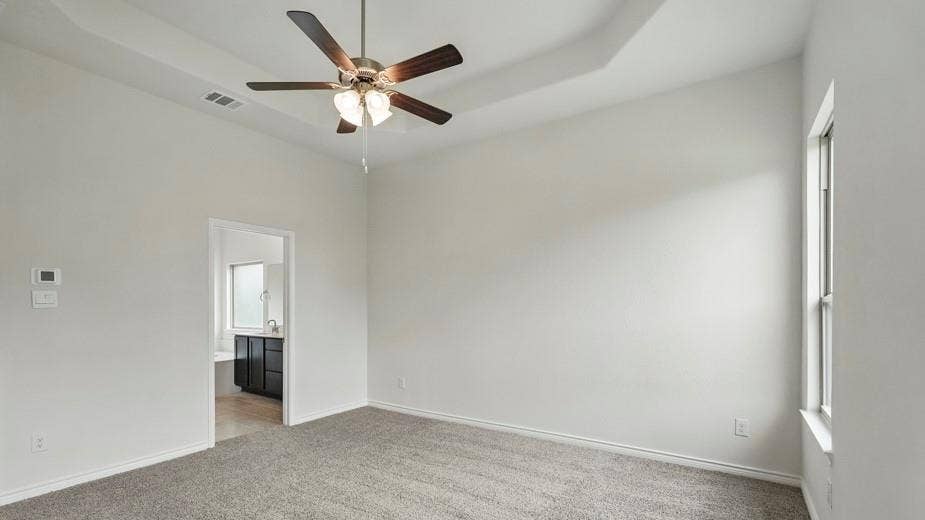 2510 Wesley Avenue, Royse City, TX 75189 Spacious room featuring gray carpeting, a tray ceiling, and a ceiling fan with integrated lighting