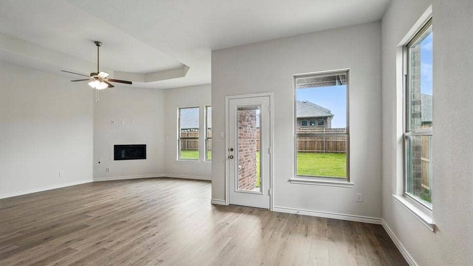 2510 Wesley Avenue, Royse City, TX 75189 Spacious living area featuring wood-finish flooring, a contemporary ceiling fan, and a built-in electric fireplace