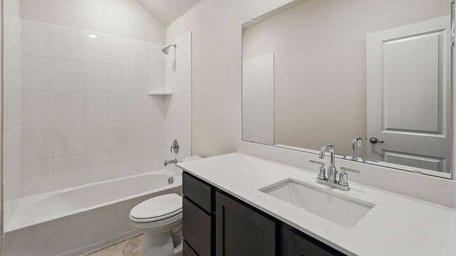 2510 Wesley Avenue, Royse City, TX 75189 Contemporary bathroom featuring a dark wood-finish vanity with a white countertop and integrated sink, a large wall-mounted mirror, and a white tiled shower/tub combination