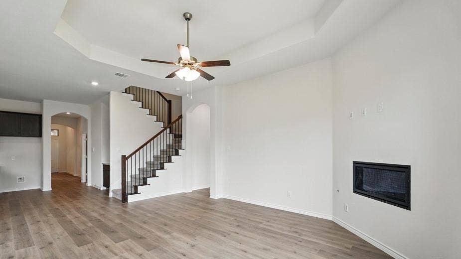 2510 Wesley Avenue, Royse City, TX 75189 Spacious living area featuring wood-finish flooring, a recessed ceiling, and an integrated fireplace