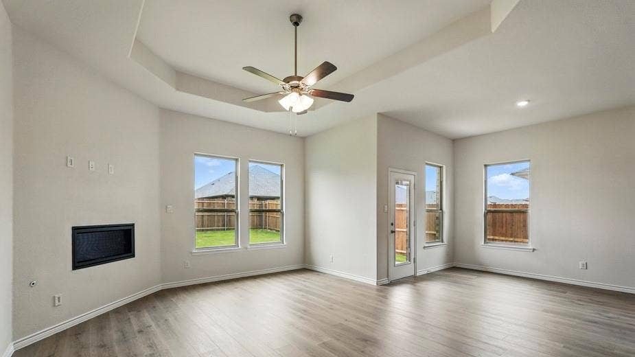 2510 Wesley Avenue, Royse City, TX 75189 Spacious living area featuring wood-finish flooring, a tray ceiling with a ceiling fan, and recessed lighting
