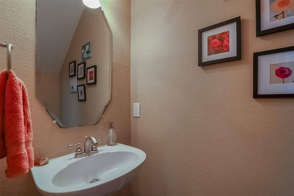 2248 Fletcher Trail, Plano, TX 75025 Pedestal sink with brushed nickel faucet, wall-mounted mirror, and overhead light fixture
