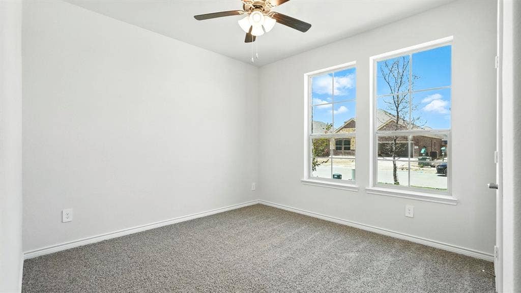 2503 Wesley Avenue, Royse City, TX 75189 Neutral tone wall paint, gray carpet flooring, white trim, and a ceiling fan with light fixture