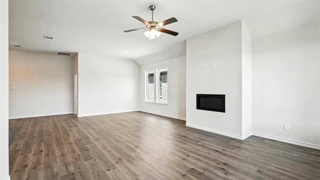 2503 Wesley Avenue, Royse City, TX 75189 Spacious living area featuring wood-finish flooring, a contemporary built-in fireplace, and a ceiling fan
