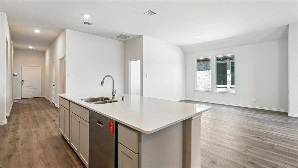 2503 Wesley Avenue, Royse City, TX 75189 Kitchen island with a stainless steel double basin sink, modern faucet, integrated dishwasher, and light-toned countertop