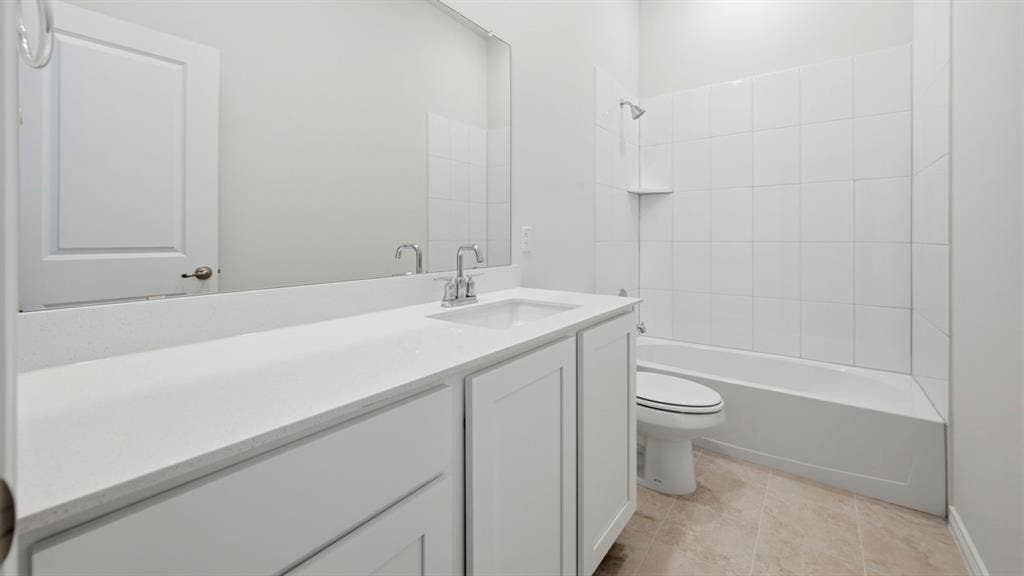 2506 Wesley Avenue, Royse City, TX 75189 Bright bathroom featuring a single vanity with a white countertop and undermount sink, a large wall-mounted mirror, a white paneled door, a white tiled shower/tub combination, and neutral-toned floor tiling