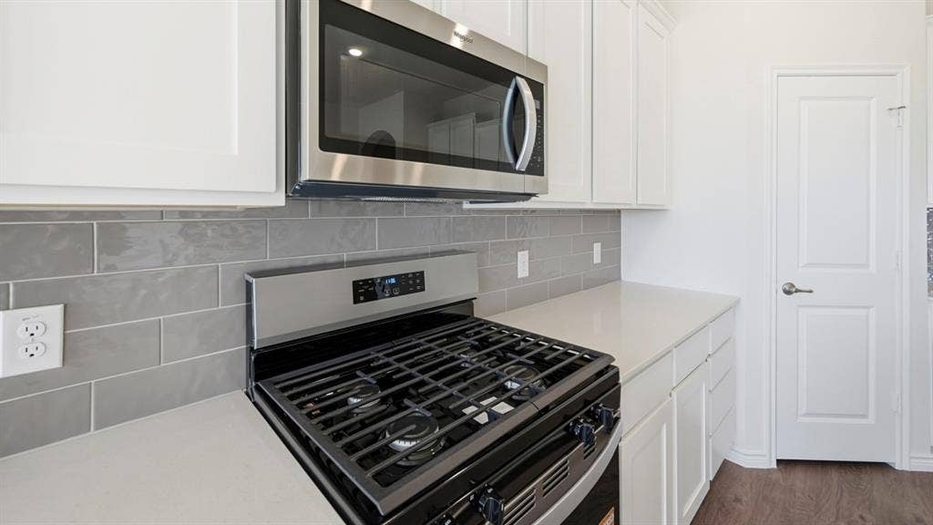 2506 Wesley Avenue, Royse City, TX 75189 Stainless steel range with gas burners, complemented by an over-the-range microwave