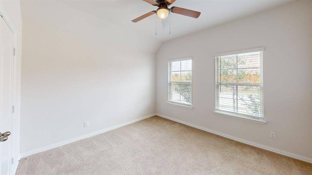 1004 Copper Smith Way, Forney, TX 75126 Vaulted ceiling, ceiling fan with integrated lighting, two windows with blinds, carpeted flooring, and white trim