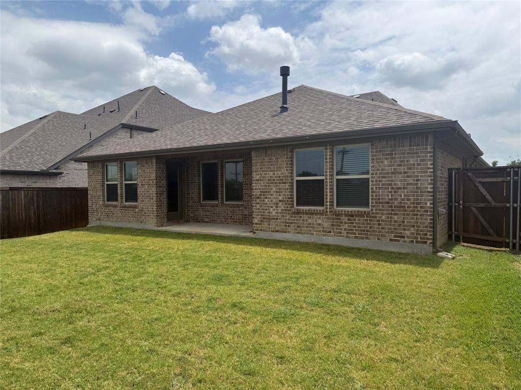 1004 Copper Smith Way, Forney, TX 75126 Brick exterior with a covered patio, fenced yard, and composition shingle roof