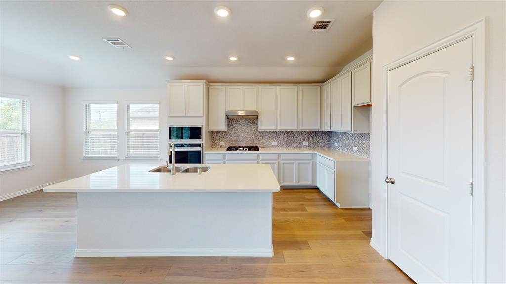 1004 Copper Smith Way, Forney, TX 75126 Expansive kitchen island with an undermount sink and contemporary faucet