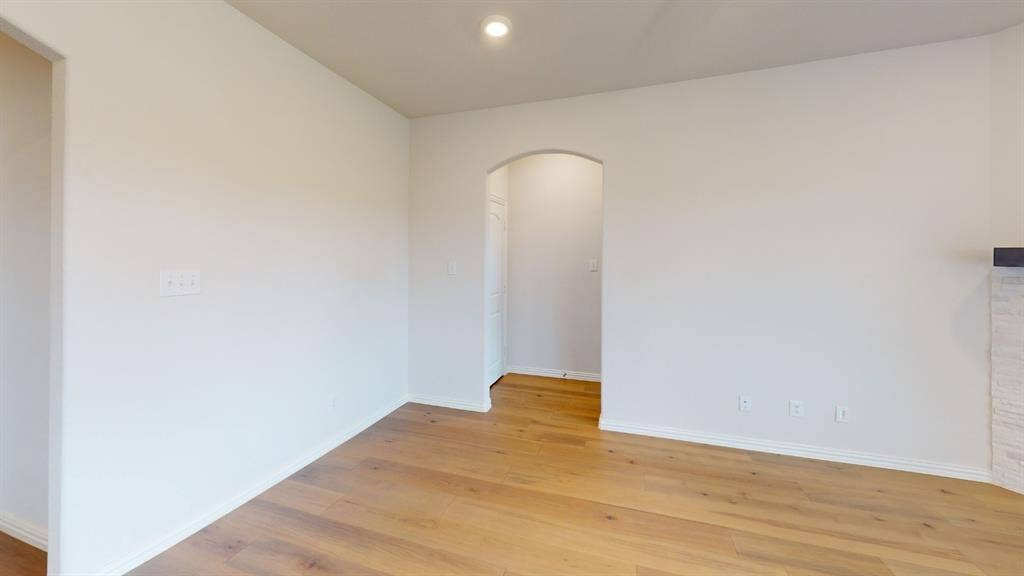 1004 Copper Smith Way, Forney, TX 75126 Wood-finish flooring, recessed ceiling lighting, arched doorway, and white painted walls