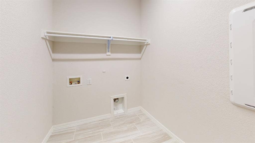 1004 Copper Smith Way, Forney, TX 75126 Utility area featuring tile flooring, a built-in shelf, and a clothing rod