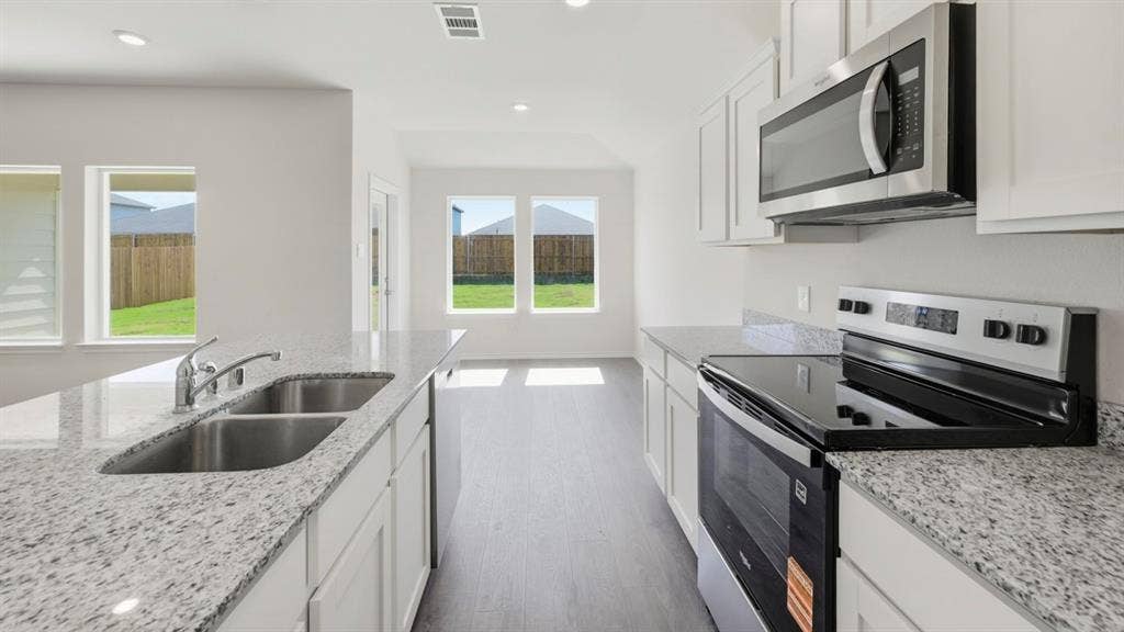 443 Epiphany Lane, Lavon, TX 75166 Kitchen featuring white cabinetry, light-colored countertops, stainless steel appliances, and wood-finish flooring
