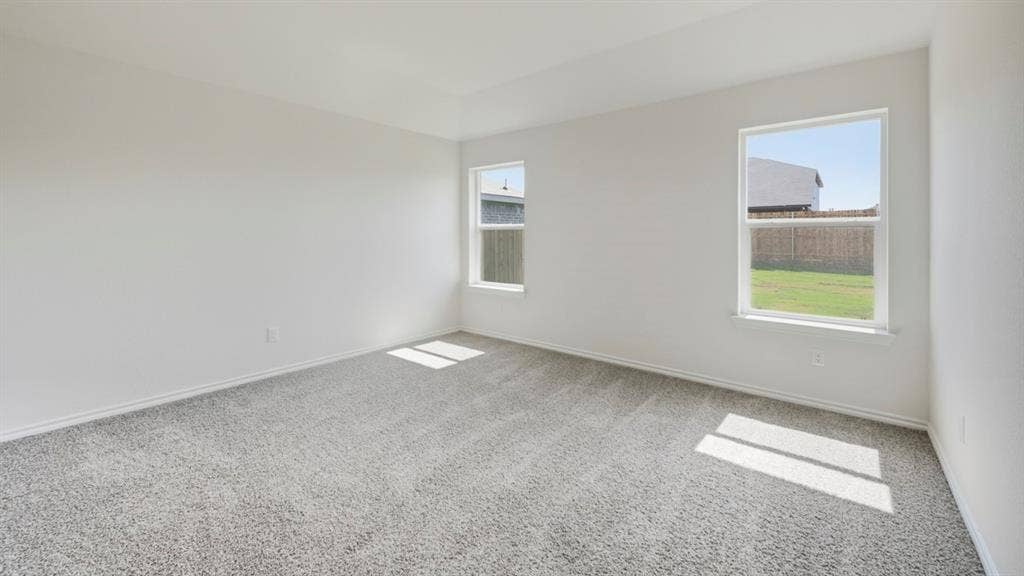 443 Epiphany Lane, Lavon, TX 75166 Spacious room featuring light gray carpeting, neutral wall paint, white trim, and two large windows offering ample natural illumination