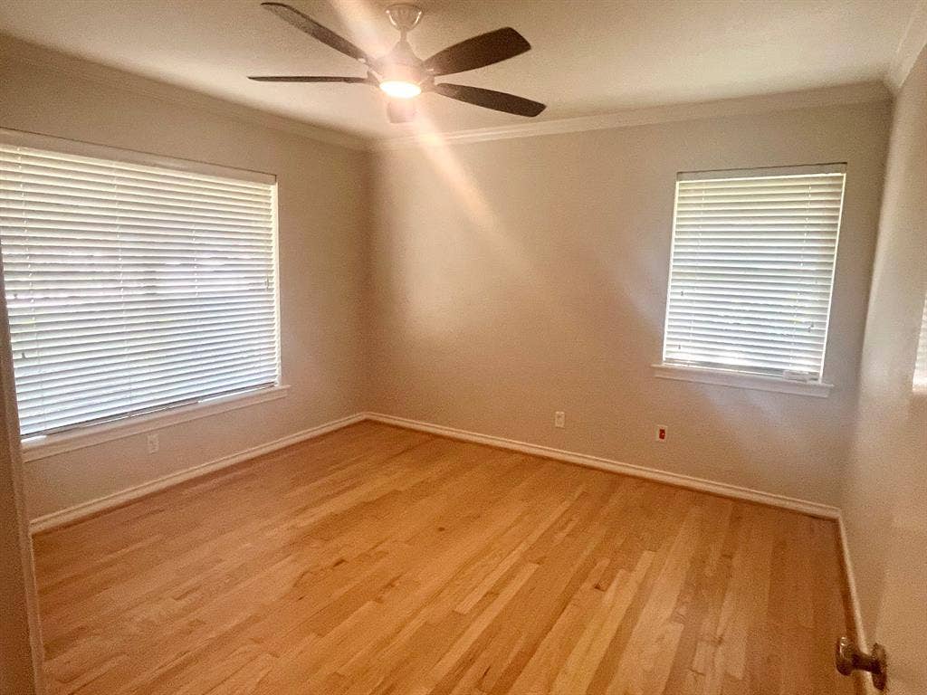 10409 Remington Lane, Dallas, TX 75229 Hardwood flooring, two windows with blinds, ceiling fan with integrated lighting, and crown molding