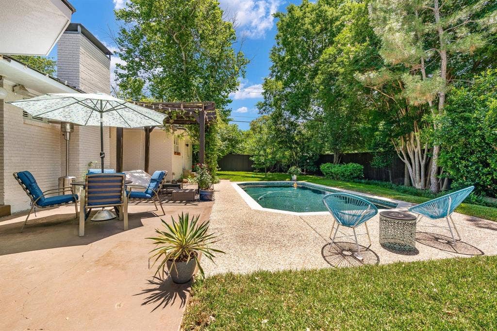 10409 Remington Lane, Dallas, TX 75229 Backyard with a swimming pool, concrete patio, and mature trees