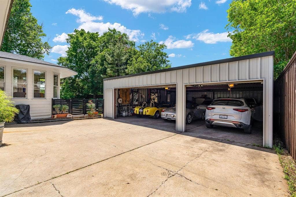 10409 Remington Lane, Dallas, TX 75229 Detached multi-bay garage with electric car charger, a flat black roof, and concrete floor