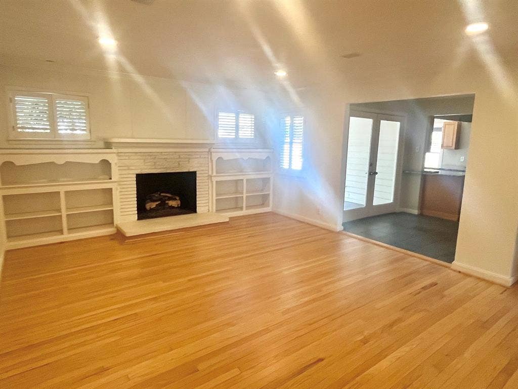 10409 Remington Lane, Dallas, TX 75229 Hardwood flooring, recessed lighting, built-in shelving, stone-clad fireplace, and plantation shutters