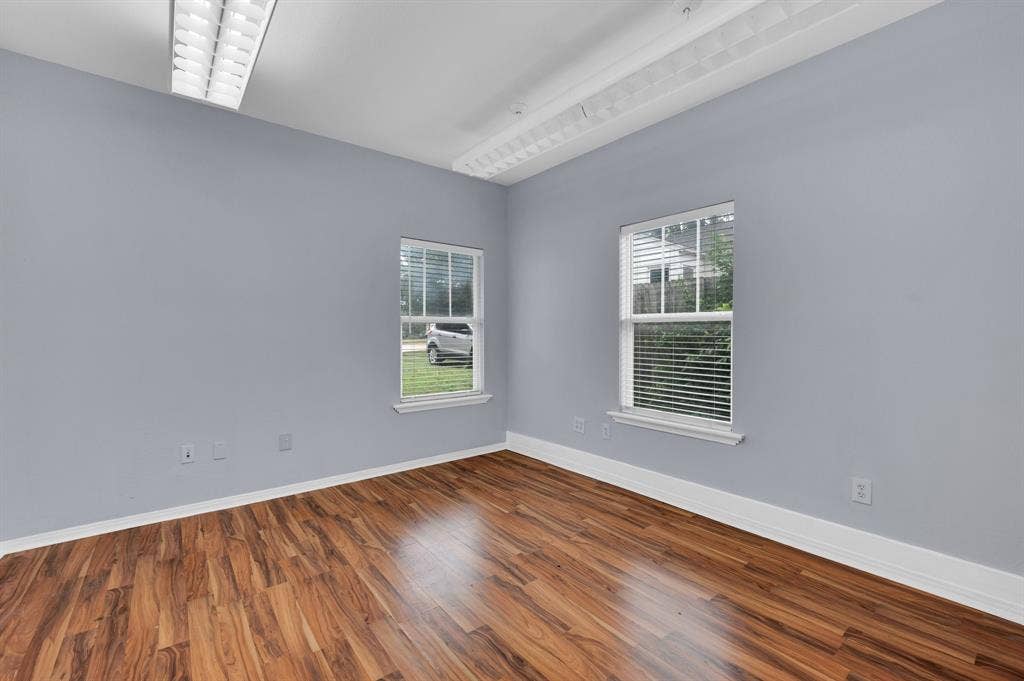 214 W Belt Line Road, #B, Cedar Hill, TX 75104 Wood-finish flooring, white window frames with blinds, white baseboards, and overhead fluorescent lighting