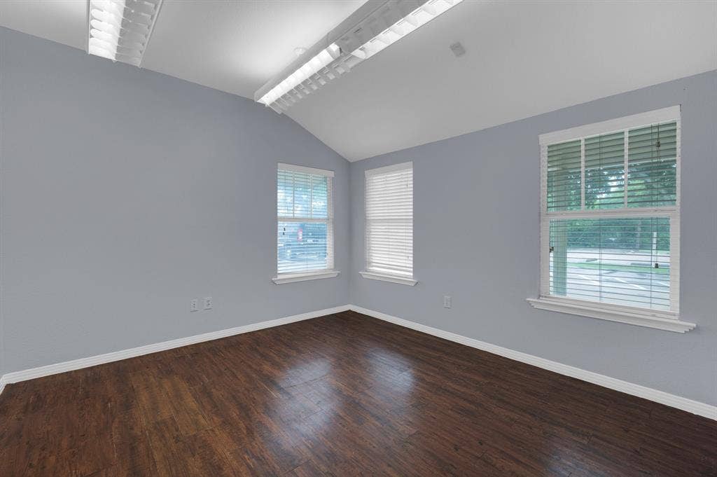 214 W Belt Line Road, #B, Cedar Hill, TX 75104 Vaulted ceiling, wood-finish flooring, multiple windows, white window blinds, and overhead fluorescent lighting