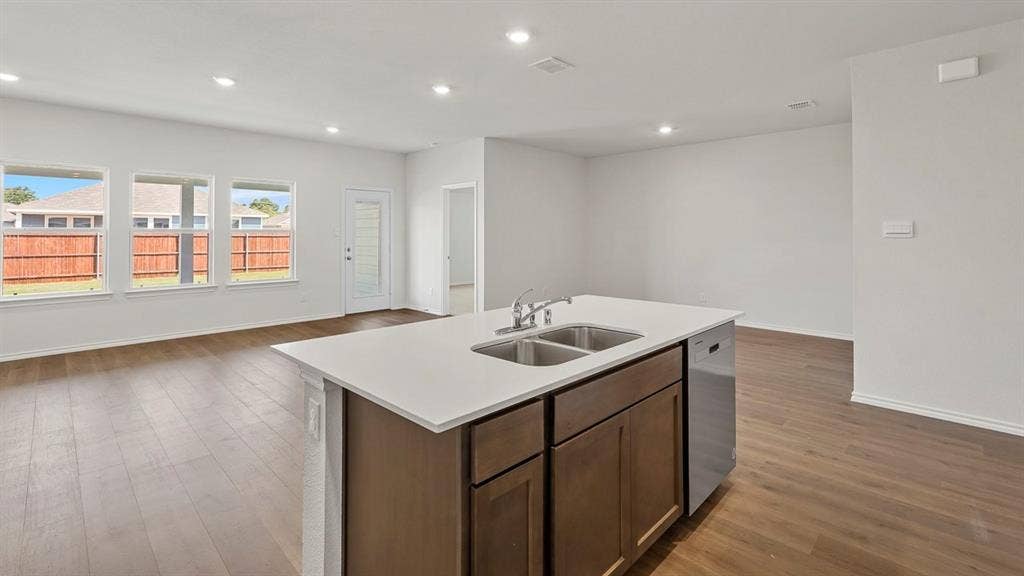 809 Brook Lane, Josephine, TX 75135 Kitchen island with dual stainless steel sinks, a built-in dishwasher, and a light-colored countertop