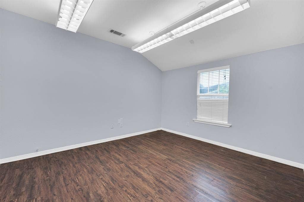 214 W Belt Line Road, #C, Cedar Hill, TX 75104 Vaulted ceiling, wood-finish flooring, natural light through a single window, and bright overhead lighting
