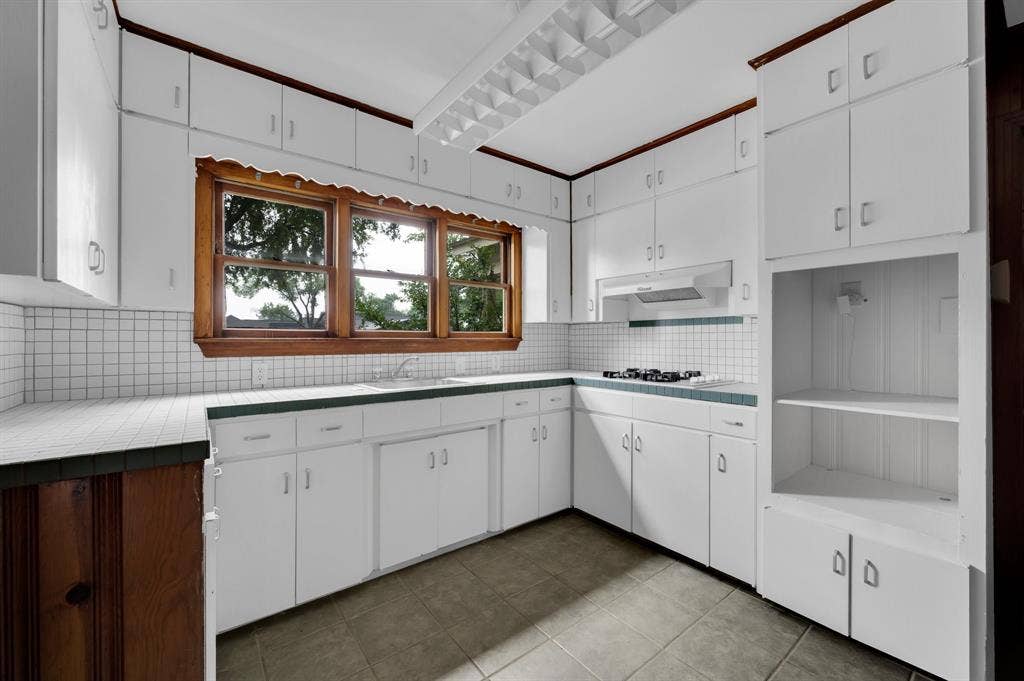 216 W Belt Line Road, Cedar Hill, TX 75104 White cabinetry with abundant storage, wood-frame windows, tiled countertops, and a four-burner gas range