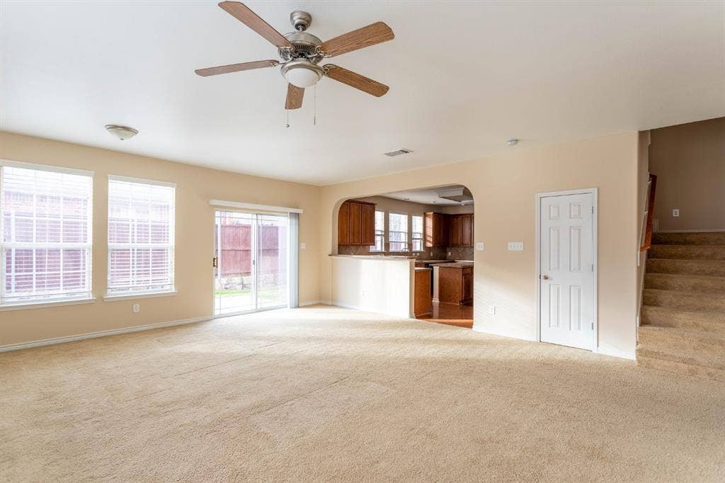 6509 Hickory Hill Drive, Plano, TX 75074 Spacious living area featuring carpet flooring, ceiling fan, and multiple windows with blinds