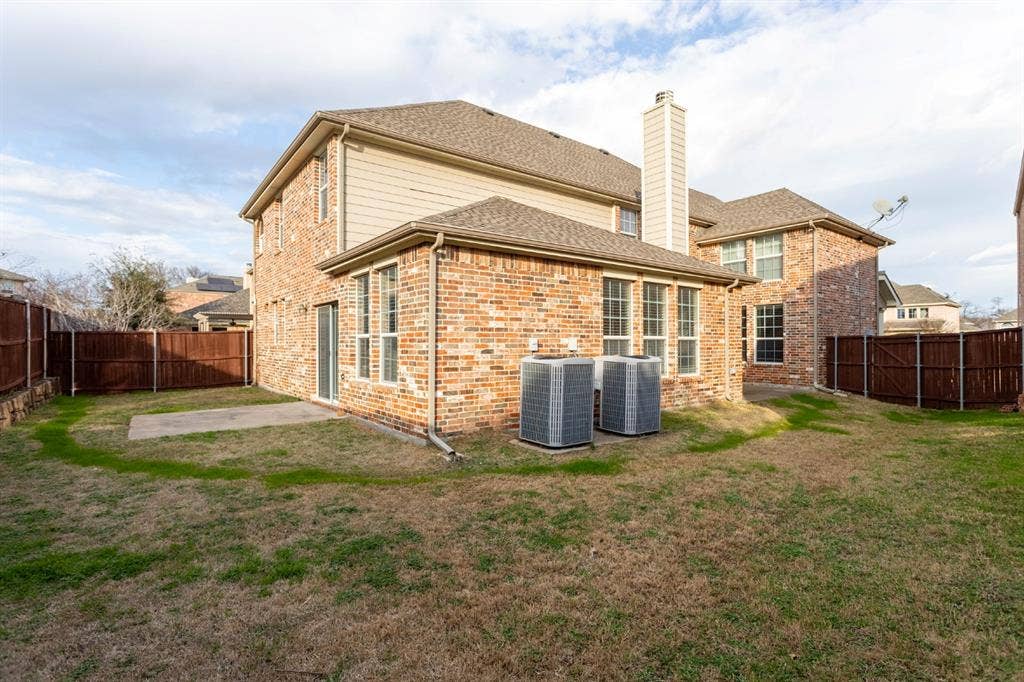 6509 Hickory Hill Drive, Plano, TX 75074 Brick and siding exterior with multiple windows and a concrete patio