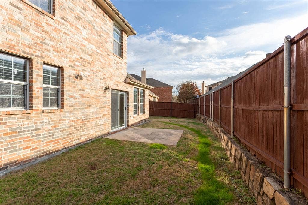 6509 Hickory Hill Drive, Plano, TX 75074 Brick exterior with multiple windows and a sliding glass door