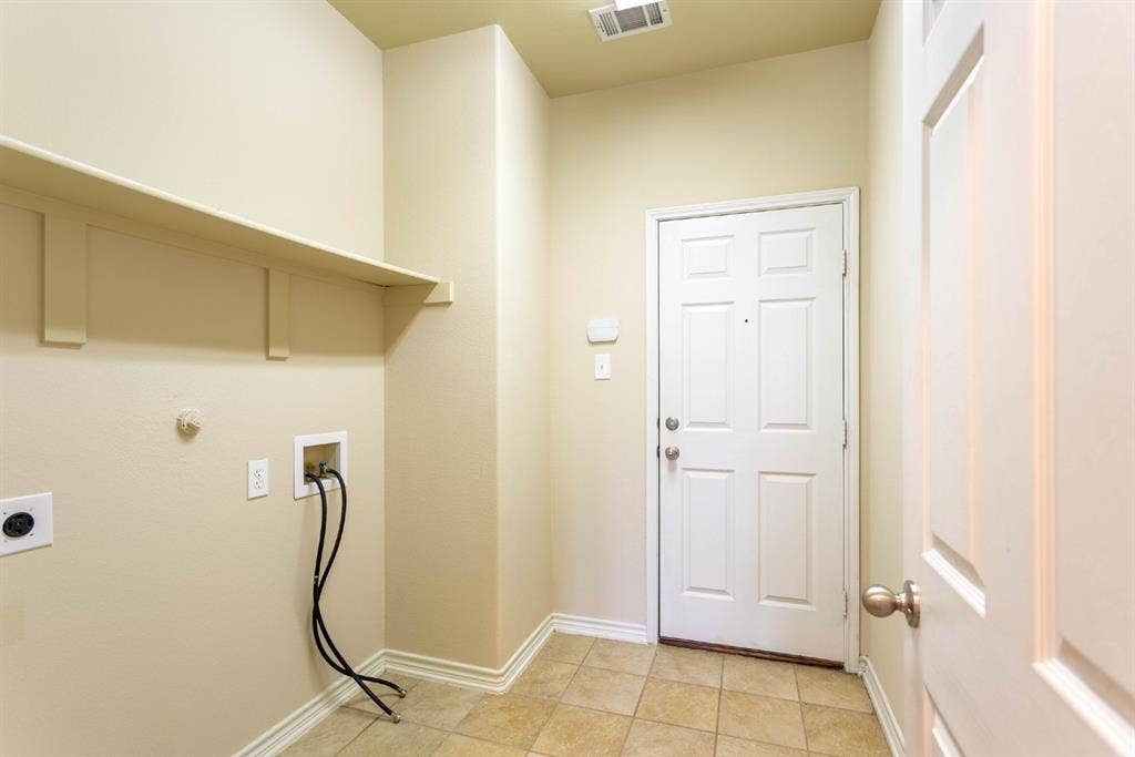 6509 Hickory Hill Drive, Plano, TX 75074 Tile flooring, built-in shelving, white paneled doors, and a laundry hookup