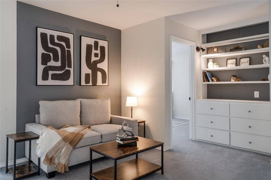 Integrated built-in shelving with lower storage drawers, recessed lighting, and a textured accent wall