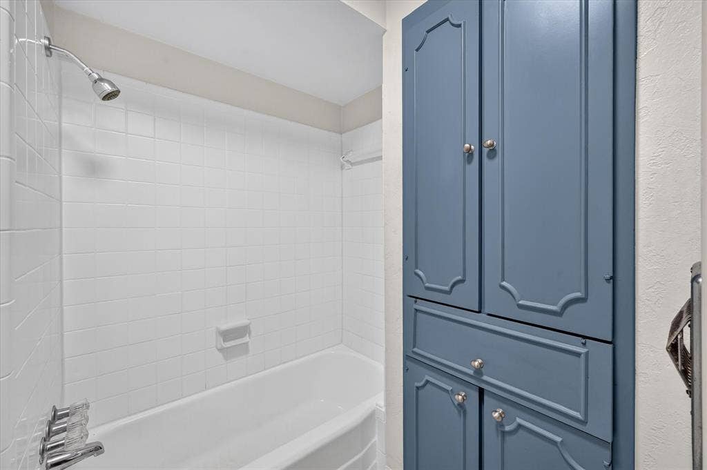 5043 Les Chateaux Drive, #214, Dallas, TX 75235 White subway tile shower surround with a built-in tub and chrome fixtures