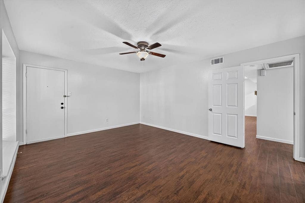 5043 Les Chateaux Drive, #214, Dallas, TX 75235 Spacious room featuring vinyl plank wood like finish flooring, a ceiling fan with integrated lighting, white walls, and white doors
