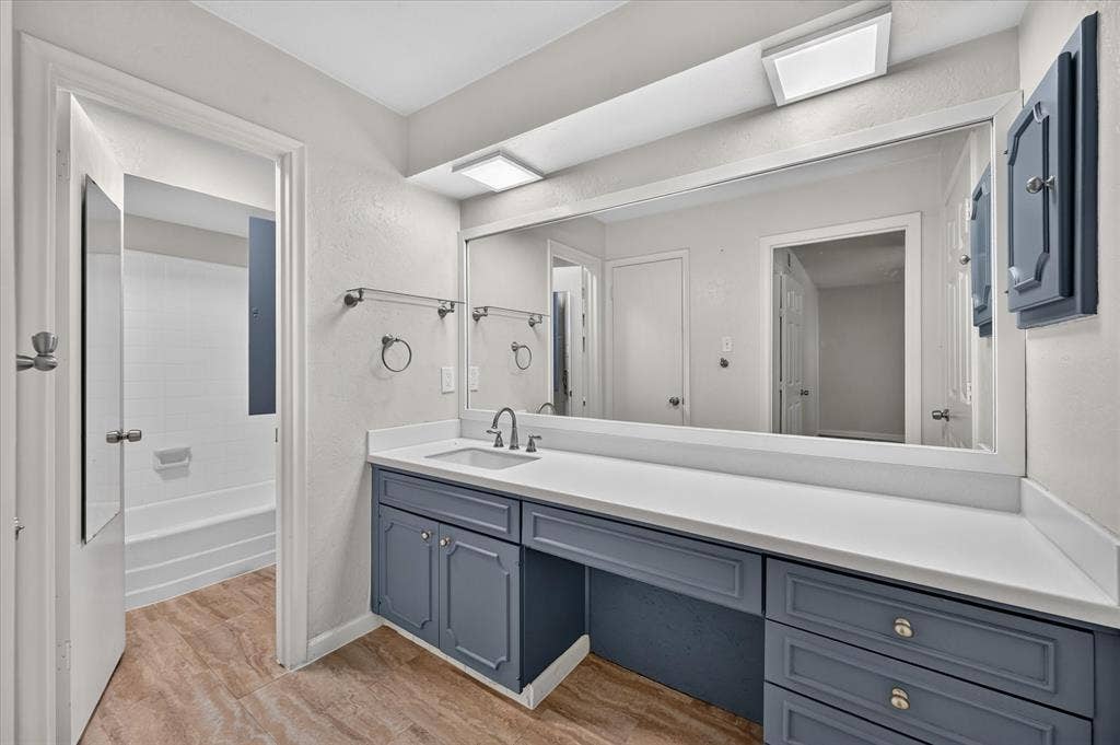 5043 Les Chateaux Drive, #214, Dallas, TX 75235 Vanity featuring a single basin, white countertop, and blue cabinetry, tile flooring