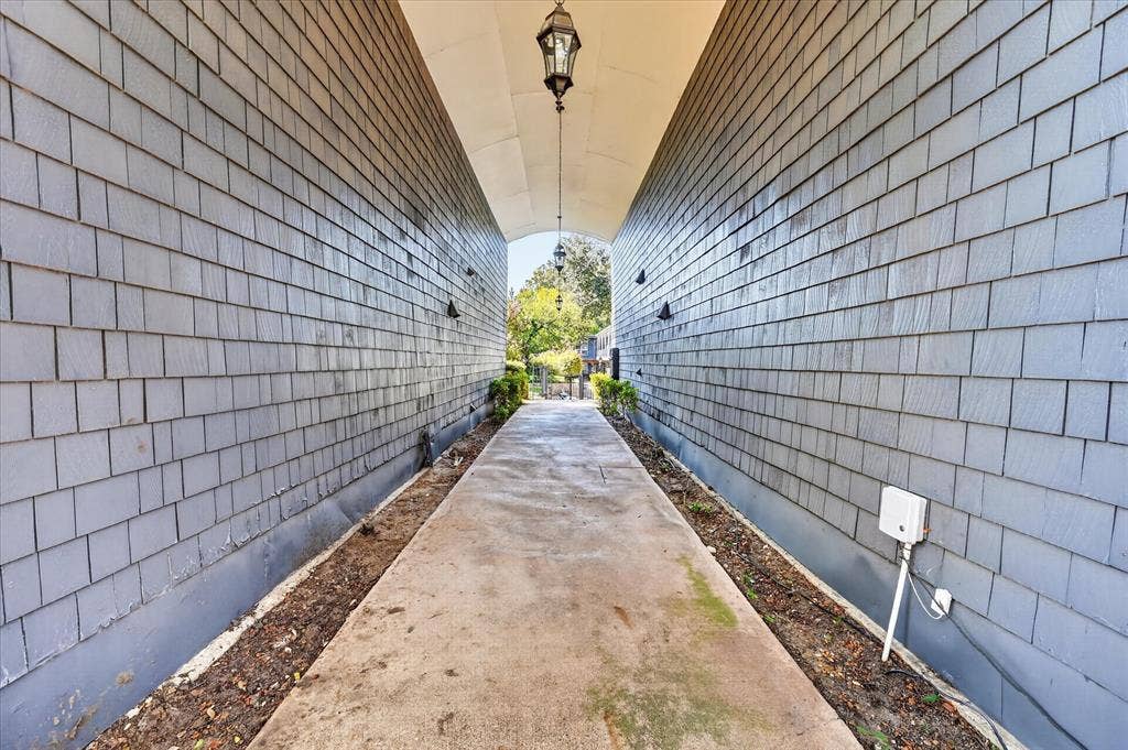 5043 Les Chateaux Drive, #214, Dallas, TX 75235 Covered walkway with shake siding, overhead lantern light fixture, and concrete pathway