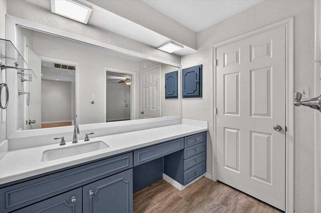 5043 Les Chateaux Drive, #214, Dallas, TX 75235 Vanity with integrated sink, expansive counter space, vinyl tile flooring, and a large wall-mounted mirror