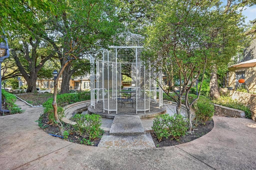 5043 Les Chateaux Drive, #214, Dallas, TX 75235 Paved pathway with mature trees, a metal gazebo, and surrounding landscaping