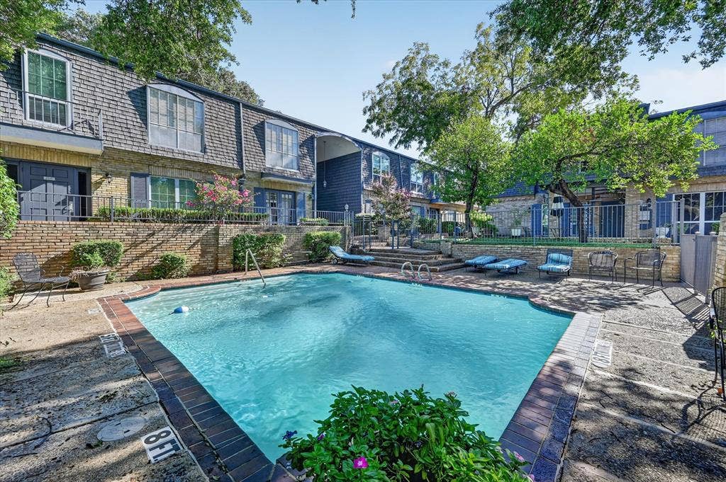 5043 Les Chateaux Drive, #214, Dallas, TX 75235 Community swimming pool with water features, surrounded by mature trees