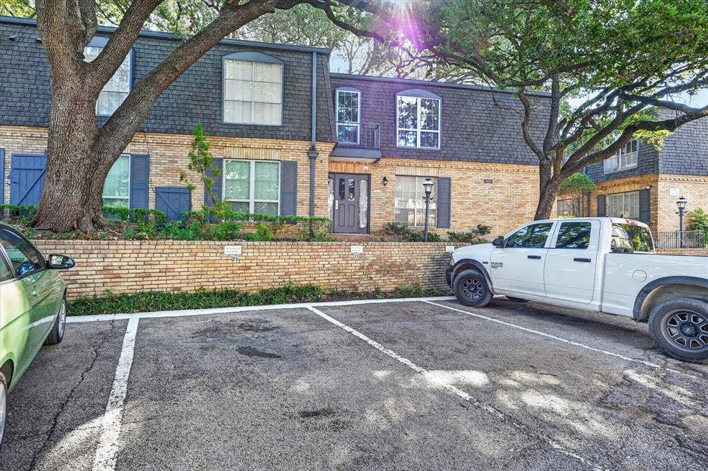 5043 Les Chateaux Drive, #214, Dallas, TX 75235 Brick facade with a mansard roof, dormer windows, and exterior shutters