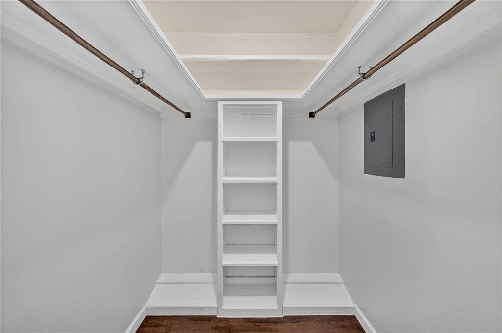 5043 Les Chateaux Drive, #214, Dallas, TX 75235 Closet space with built-in shelving, two clothing rods, and vinyl plank wood like finish flooring