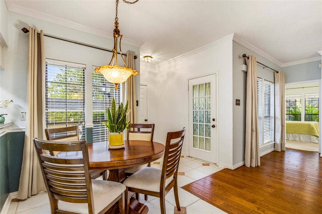 Hardwood flooring, tiled flooring with accent inlays, decorative pendant lighting, door with frosted glass panels to the patio, and multiple windows with blinds gives this a very open feel....