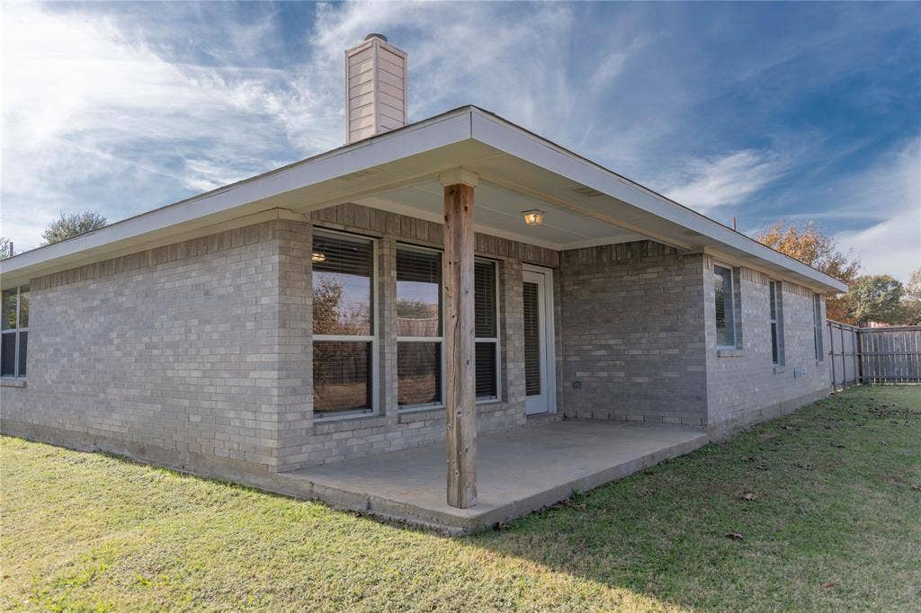 15534 Durango Drive, Frisco, TX 75035 Covered patio with a concrete slab, brick exterior, and a fenced yard