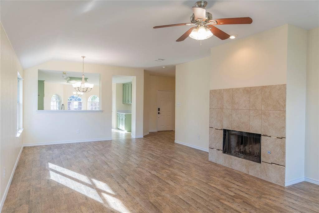 15534 Durango Drive, Frisco, TX 75035 Spacious living area featuring wood-finish flooring and a tiled fireplace