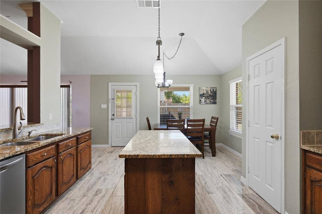 1125 Bayfield Drive, Denton, TX 76209 Kitchen featuring wood cabinetry, granite countertops, a stainless steel sink, and wood-finish flooring