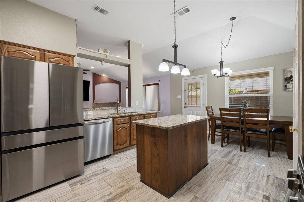 1125 Bayfield Drive, Denton, TX 76209 Kitchen featuring wood-finish cabinetry, granite countertops, and stainless steel appliances