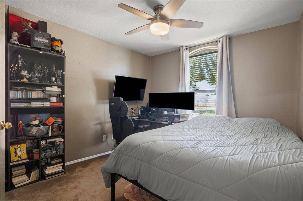 1125 Bayfield Drive, Denton, TX 76209 Recessed window with blinds, ceiling fan with integrated lighting, wall-mounted television, and brown carpeting