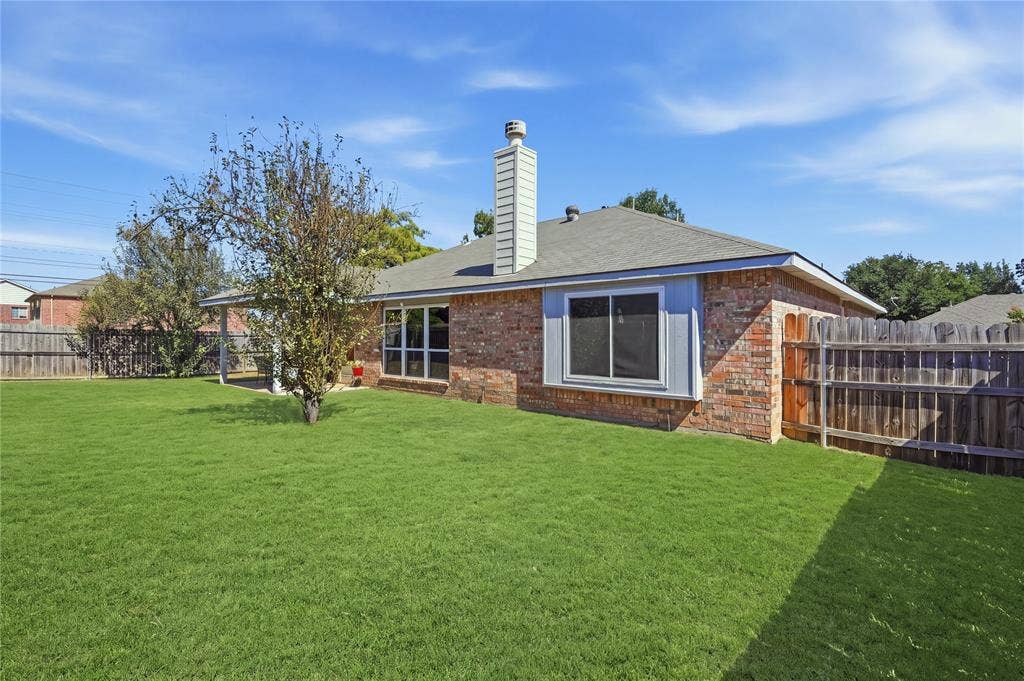 1125 Bayfield Drive, Denton, TX 76209 Brick exterior with a gray shingle roof and a prominent chimney
